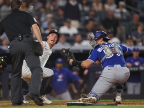 Yankees' Anthony Volpe slides into home plate to score past Jays' Brandon Valenzuela during the fourth inning at Yankee Stadium on May 18, 2026. Ishika Samant/Getty Images
