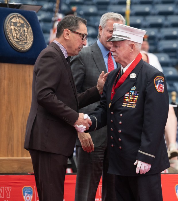 FDNY Commissioner Daniel Nigro (left) shakes the hand of Rescue 3 Lt. Michael "Mickey" Conboy after Conboy received the Dr. Harry M. Archer Medal at the 2021 FDNY Medal Day at Arthur Ash Stadium in Queens on Wednesday, June 2, 2021. (Barry Williams for New York Daily News)