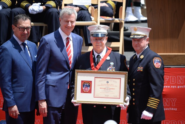 Fire Commissioner Daniel Nigro (far left), Mayor Bill de Blasio (2nd from left) and Chief of Department James Leonard (far right) present Lt. Michael "Mickey" Conboy of Rescue Company 3 with the James Gordon Bennett Medal and NYS Honorary Fire Chiefs Association Medal at the annual FDNY Medal Day Ceremony on Wednesday, June 6, 2018, at City Hall Plaza in Manhattan, New York. (Sam Fuller / New York Daily News)