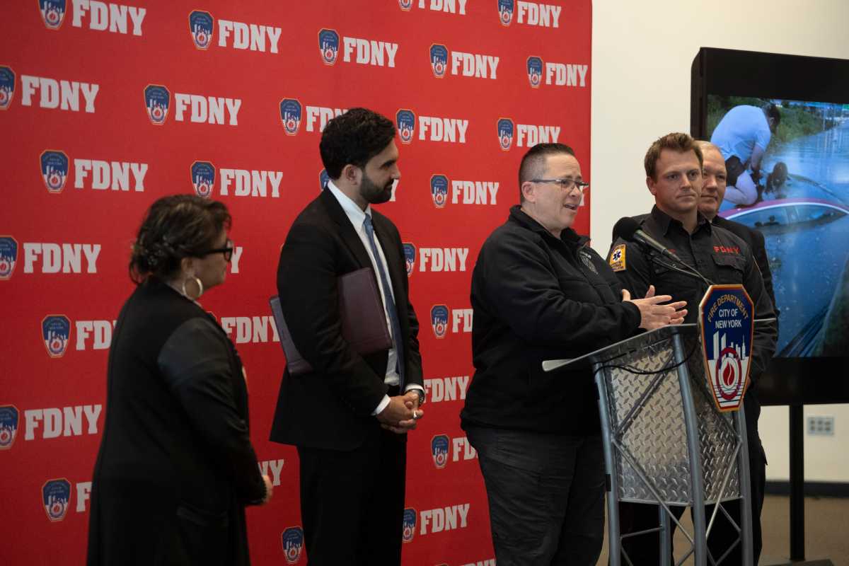 FDNY Commissioner Lillian Bonsignore praised Firefighter Travis Langan (right) who saved prinicipal Carmen Pinto from a flooded car.