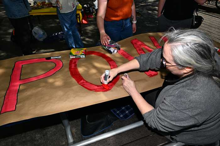 Community members work on the "Power to the Many" sign. Photo by Ramy Mahmoud.