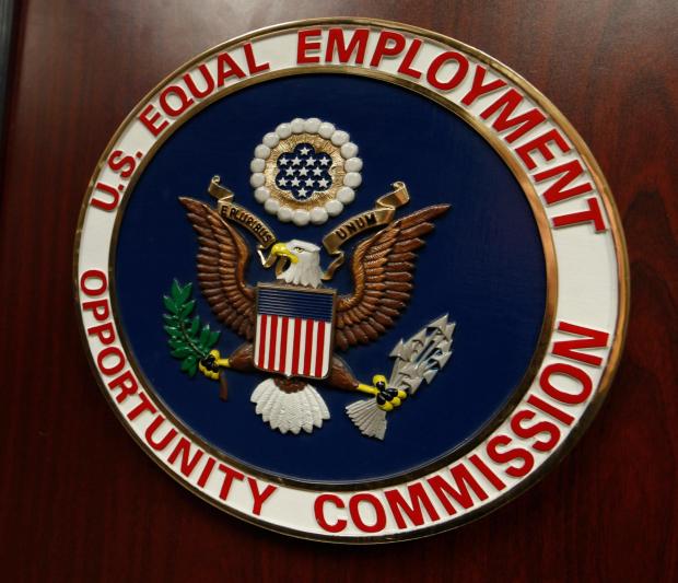 The emblem of the U.S. Equal Employment Opportunity Commission is displayed on a podium.