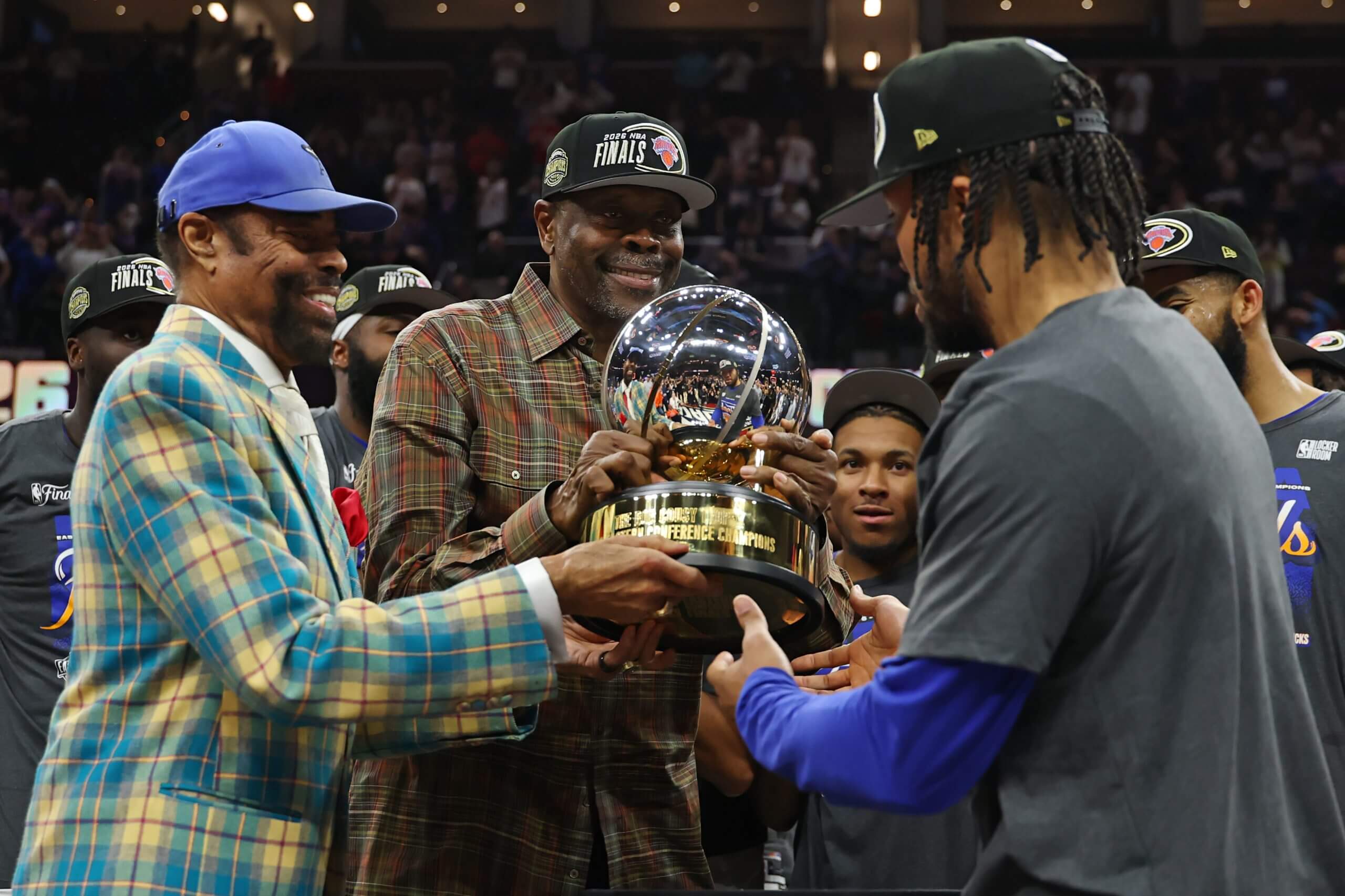 Walt Frazier, left, and Patrick Ewing present Knicks star Jalen Brunson, right, with the Eastern Conference trophy after New York defeated the Cleveland Cavaliers on Monday night in Cleveland.