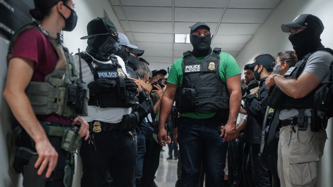 four masked ice agents in foreground