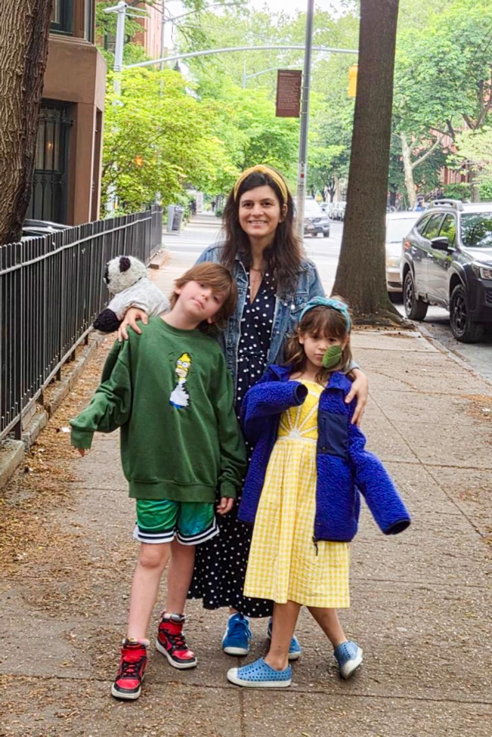 Hale walks down a city sidewalk with her two children. 