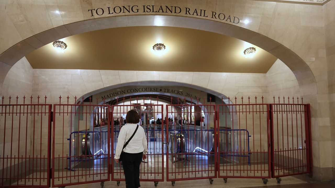 A passenger looks at a closed off entrance to the Long Island Rail Road at Grand Central station on Saturday, May 16, 2026, in New York. (AP Photo/Heather Khalifa)