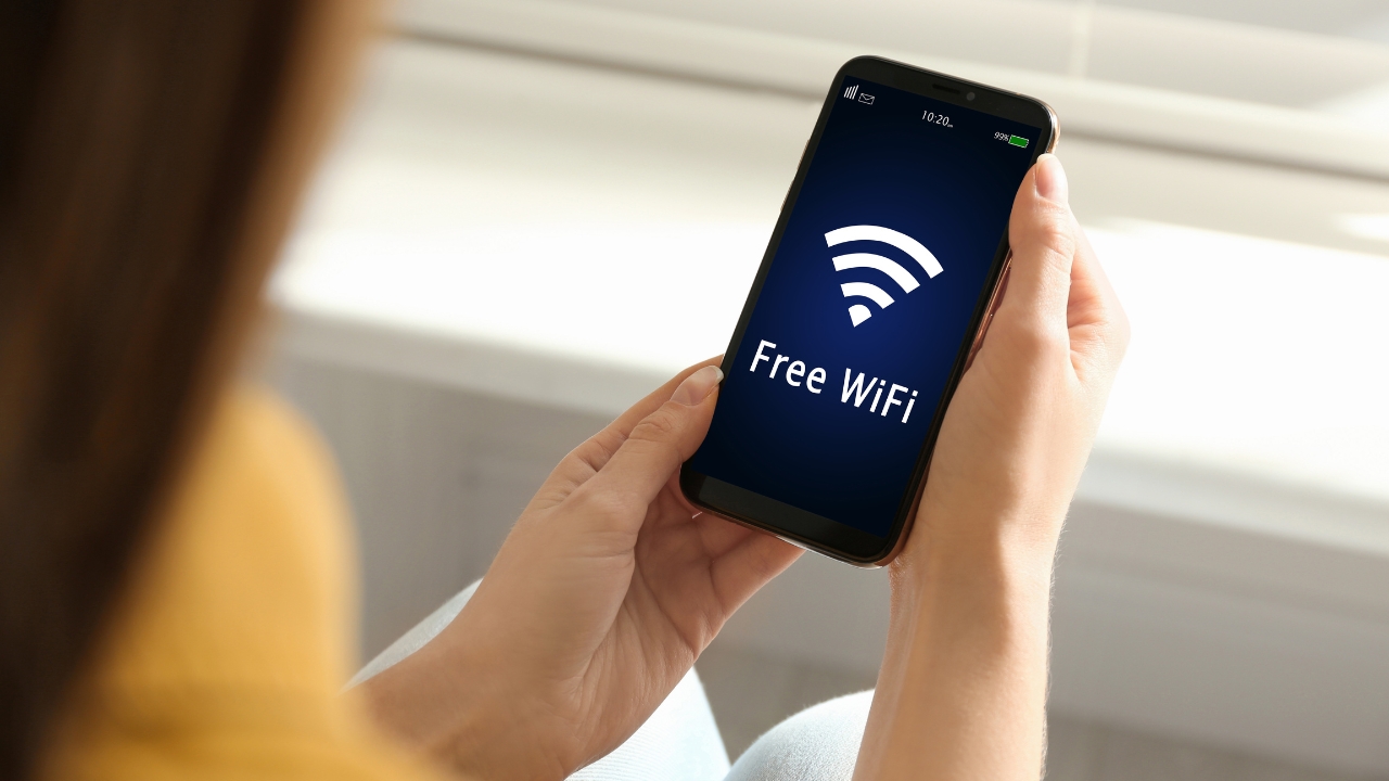 A person uses a phone below a digital network chart about internet access and data flow
