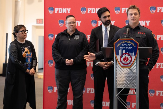 FDNY firefighter Travis Langan (right) describes rescuing Carmen Pinto (far left) as FDNY Commissioner Lillian Bonsignore and Mayor Zohran Mamdani listen at FDNY headquarters Friday, May 22, 2026 in Brooklyn, New York. (Barry Williams/ New York Daily News)
