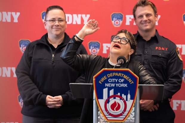Carmen Pinto (center) describes being trapped by flood waters and being rescued by FDNY firefighter Travis Langan (right) as FDNY Commissioner Lillian Bonsignore looks on during a press conference at FDNY headquarters Friday, May 22, 2026, in Brooklyn, New York. (Barry Williams/ New York Daily News)