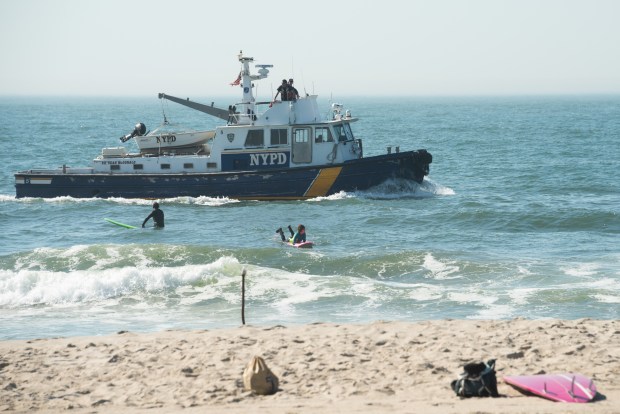 An NYPD Harbor Unit vessel searches for a missing 18-year-old swimmer at Rockaway Beach near Beach 73rd St. in Queens, New York, on Wednesday, May 20, 2026. (Gardiner Anderson / New York Daily News)