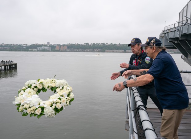 Bill Peters, Growler Former Crew Member Association, and Larry Arnold, President, Intrepid Former Crew Member Association, toss a wreath honoring crew members lost on the the U.S.S. Intrepid at the Intrepid Museum during the annual Memorial Day commemoration ceremony Monday, May 25, 2026 in Manhattan, New York. (Barry Williams/ New York Daily News)