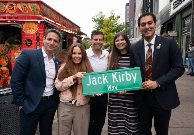 Roy Schwartz, Jack Kirby's grandchildren (L-R) Tracy Kirby, Jeremy Kirby, Jillian Kirby, and New York City Council Member Christopher Marie pose with a "Jack Kirby Way" sign during a street renaming for Jack Kirby Way at Essex St. and Delancey St. Monday, May 11, 2026 in Manhattan, New York. (Barry Williams/ New York Daily News)