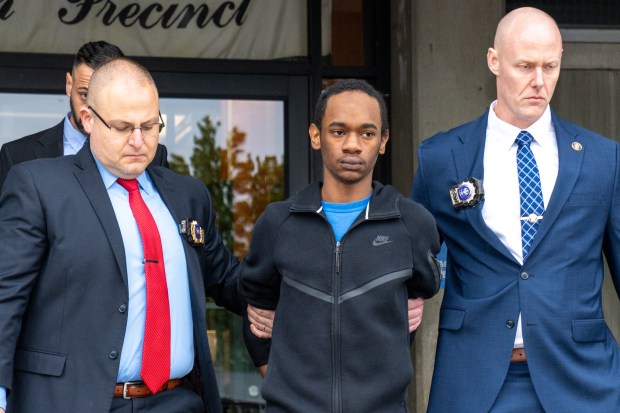 Zahir Davis, 18, is pictured in police custody outside the 113th Precinct stationhouse in Queens on Saturday.