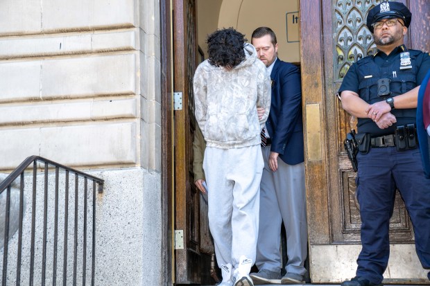 Winston Pat is pictured in police custody leaving the NYPD's 104th Precinct stationhouse in Queens on Friday, May 1, 2026. (Theodore Parisienne / New York Daily News)