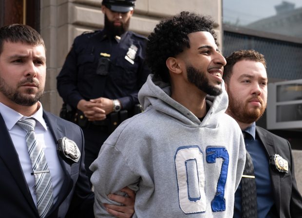 Asil Assaidi is pictured in police custody leaving the NYPD's 104th Precinct stationhouse in Queens on Thursday, April 23, 2026. (Barry Williams/ New York Daily News)