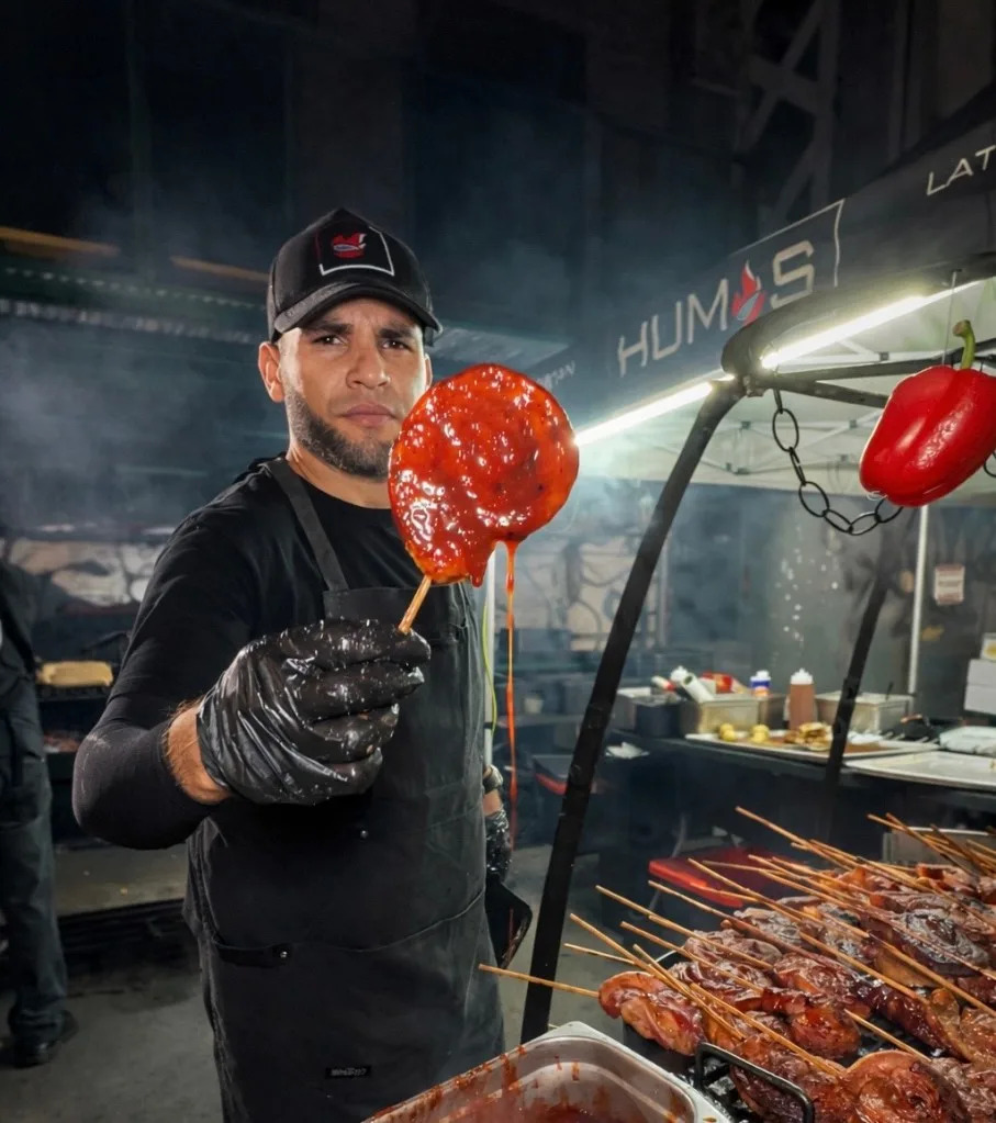 Brooklyn’s Humos Smokehouse — featuring its legendary pork belly lollipop (above) — is among the Smorgasburg vendors this year. Humos BBQ