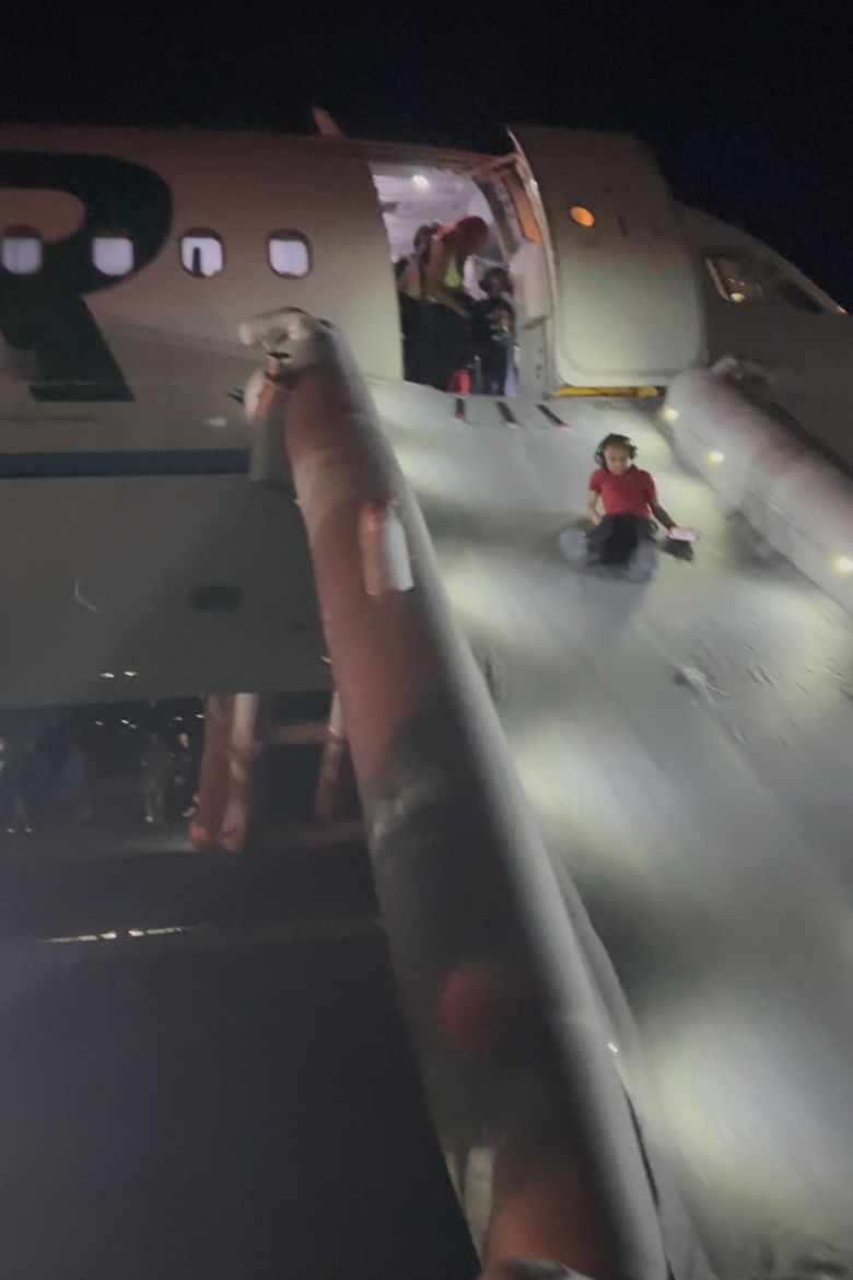 Passengers evacuate the Frontier Airlines plane that struck a pedestrian Friday in Denver.