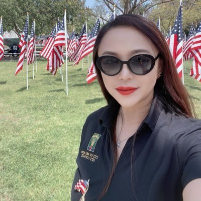 Eileen Wang in front of a field of American flags.