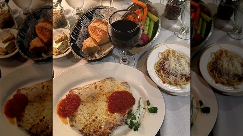 Chicken Parmigiana, wine, bread, and spaghetti served at Gene's.