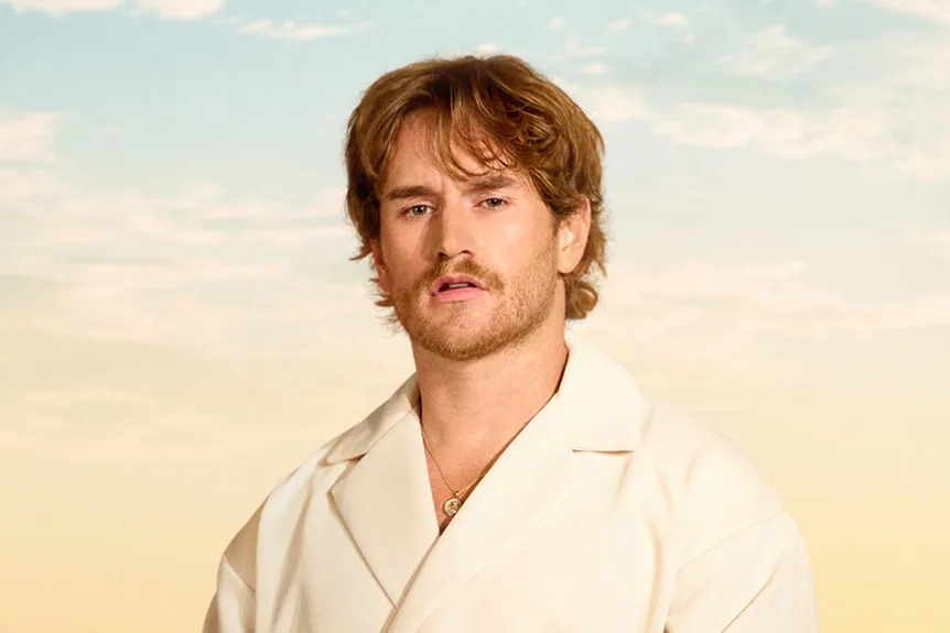 West Wilson while wearing a white top on a beach setting.