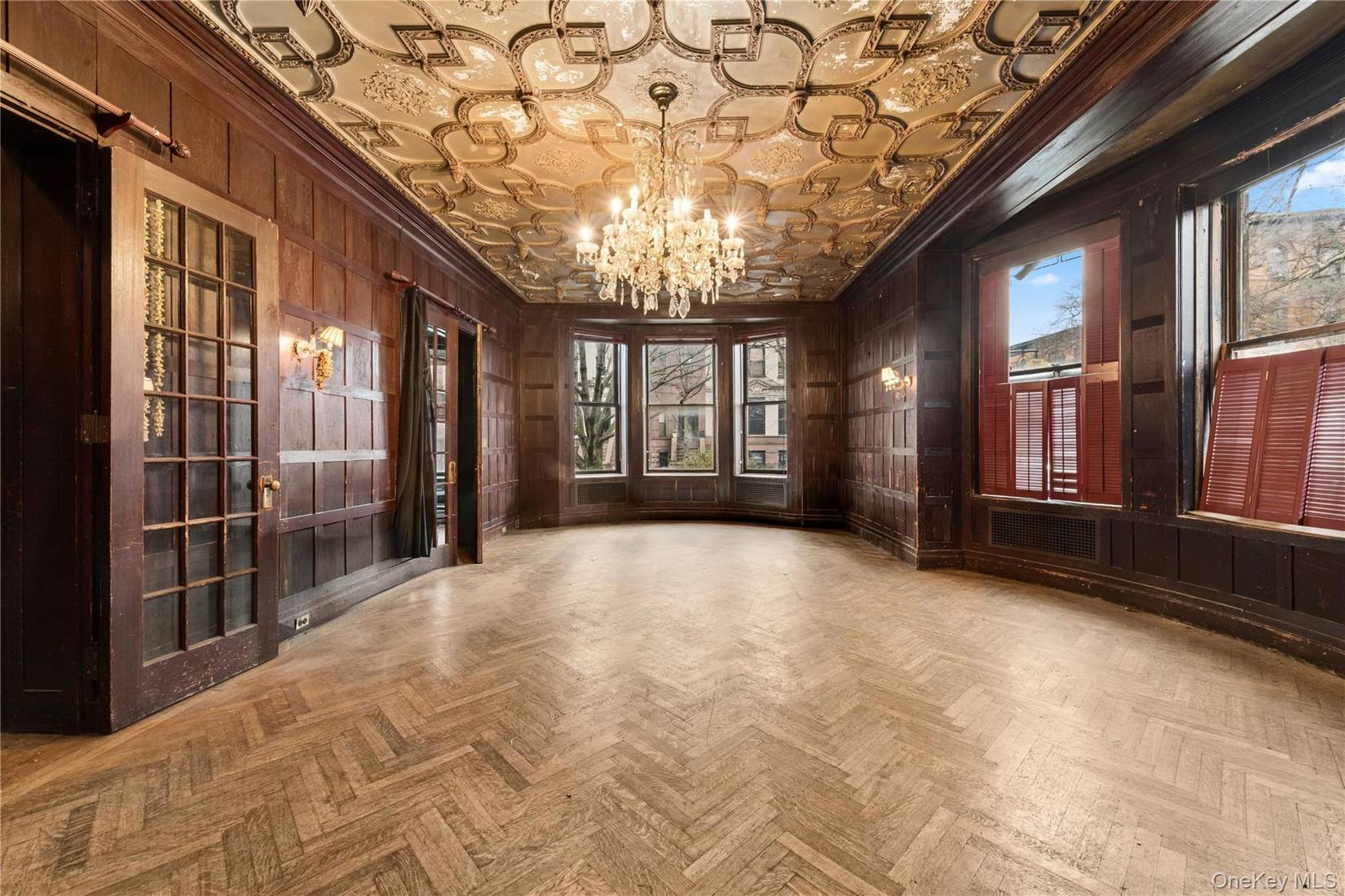 room with ornate gold ceiling, a wood floor, and paneling