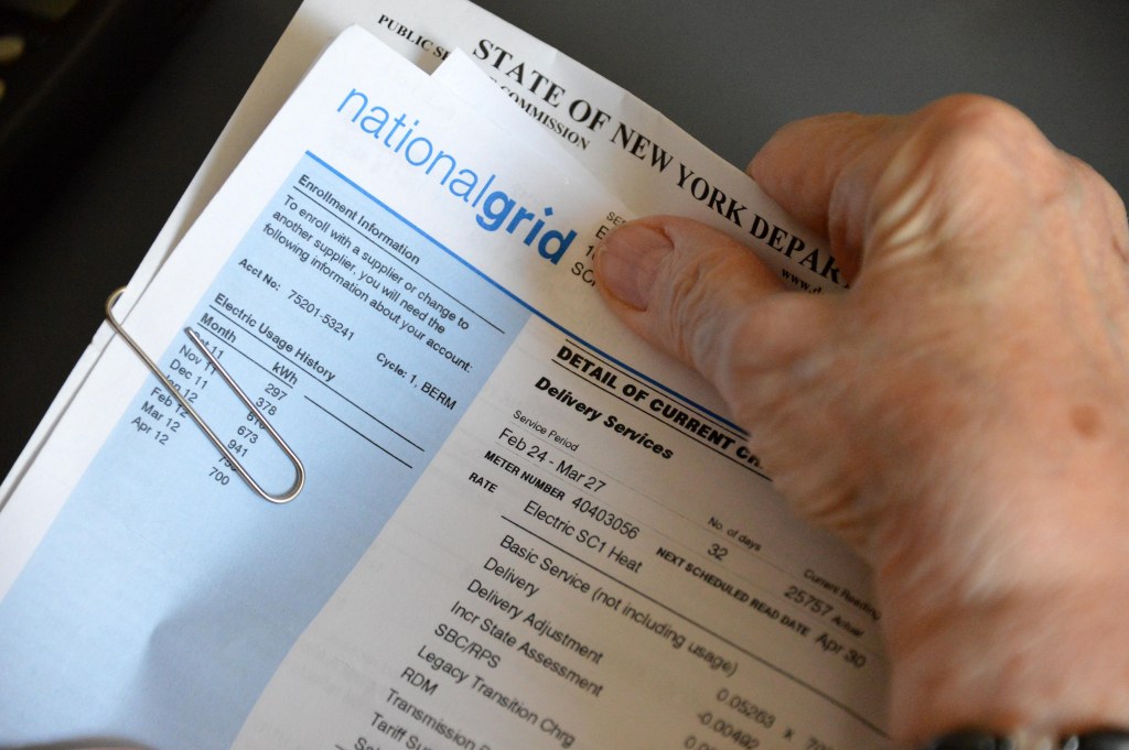Person holding an electric bill.