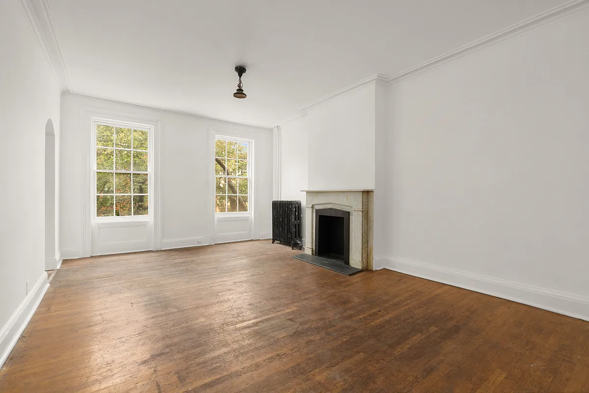 room with a marble mantel, wood floor