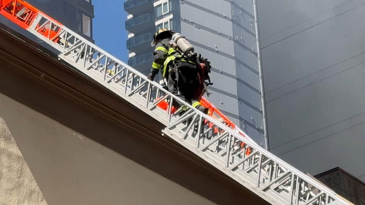 FDNY firefighter climbing a ladder.