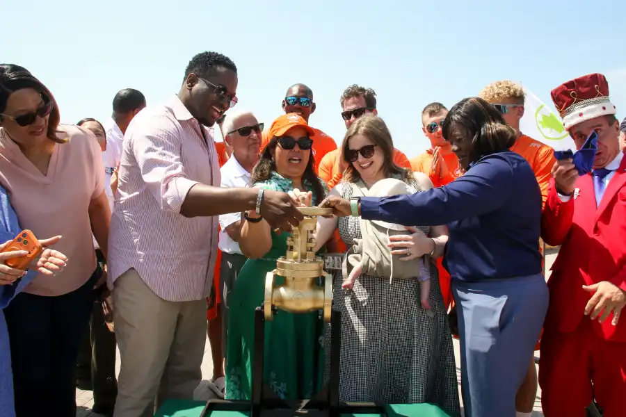 people with hands on a wheel to turn on water