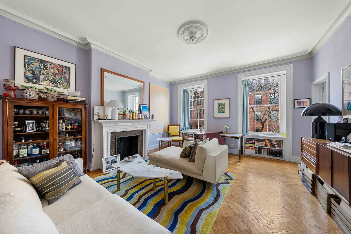 apartment living room with mantel, wood floors, purple walls