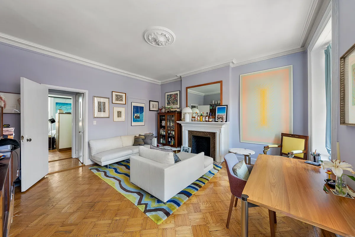 apartment living room with mantel, wood floors, purple walls