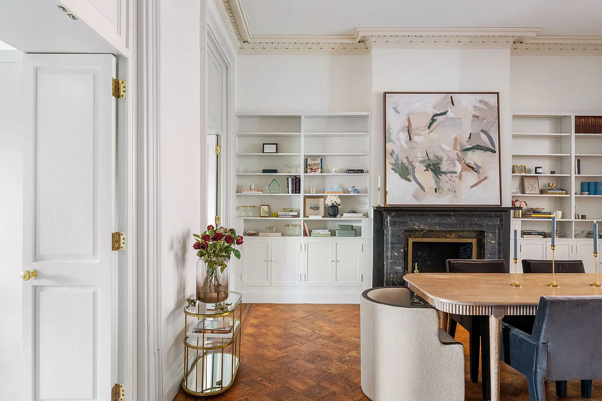 dining room with wood floor, plasterwork, mantel