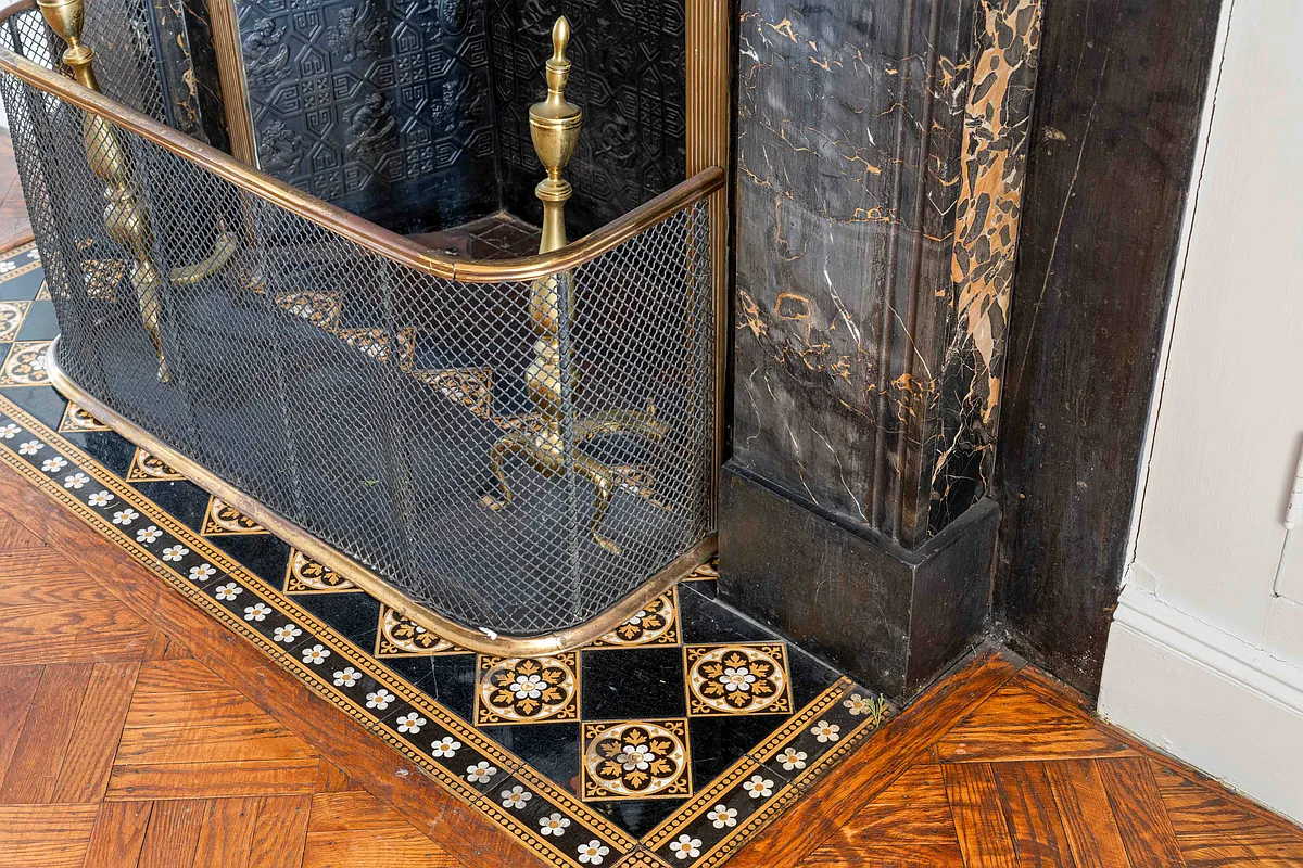 detail of tile hearth around black marble mantel