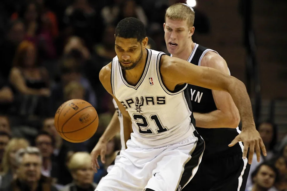 Dec 31, 2013; San Antonio, TX, USA; San Antonio Spurs forward Tim Duncan (21) is defended by Brooklyn Nets forward Mason Plumlee (behind) during the first half at AT&T Center. Mandatory Credit: Soobum Im-USA TODAY Sports