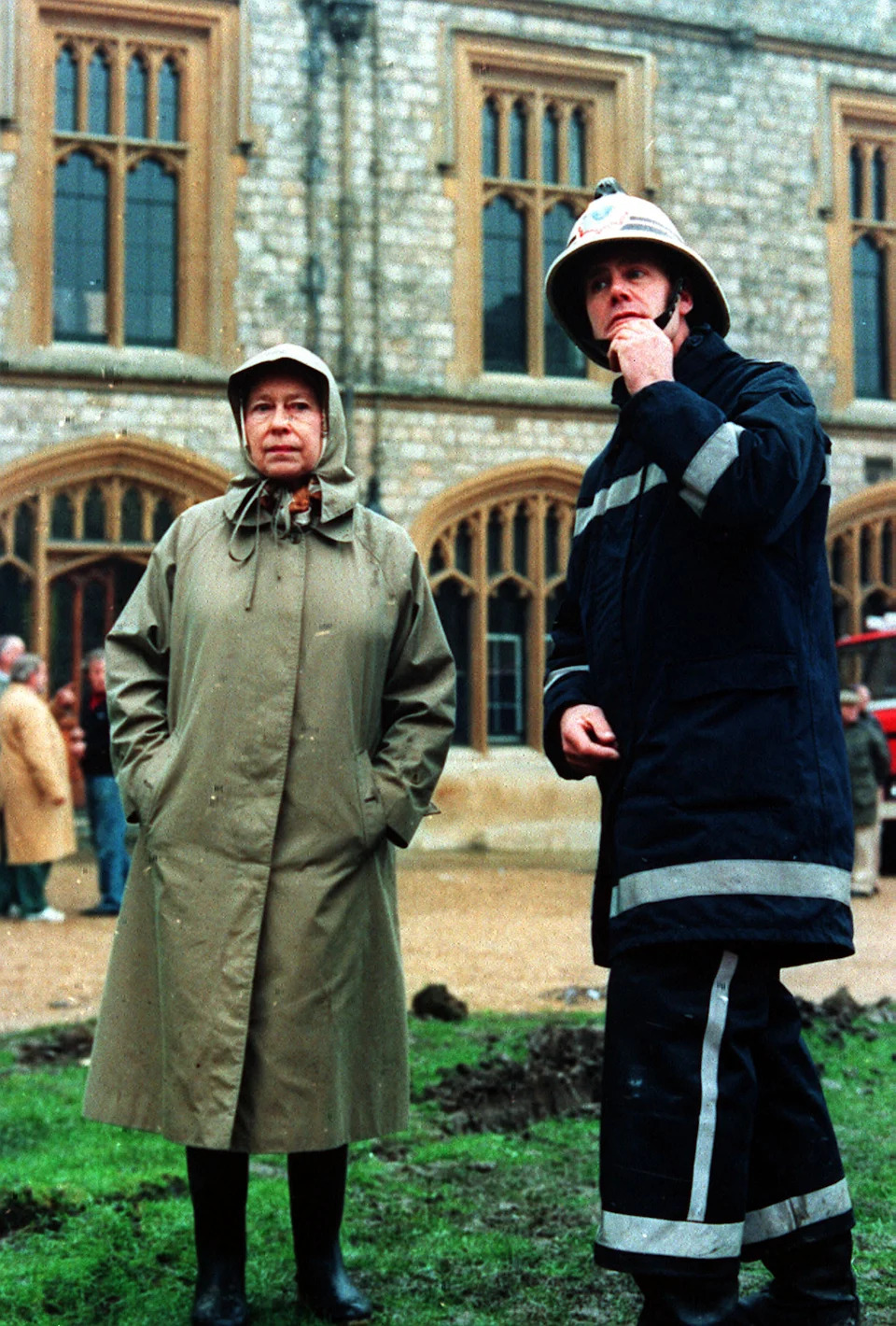 Queen Elizabeth II inspects the ruins of Windsor castle with a fireman.