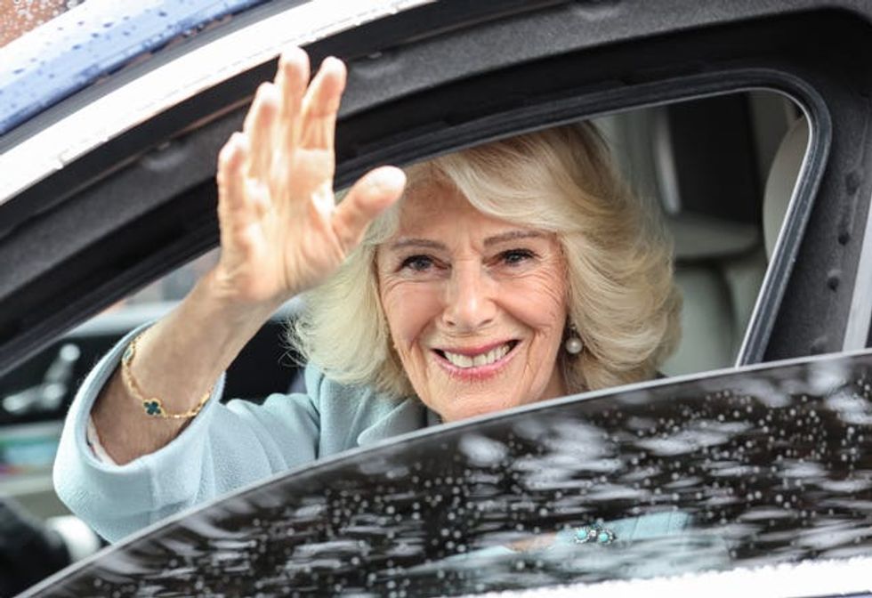 Camilla waves from a car