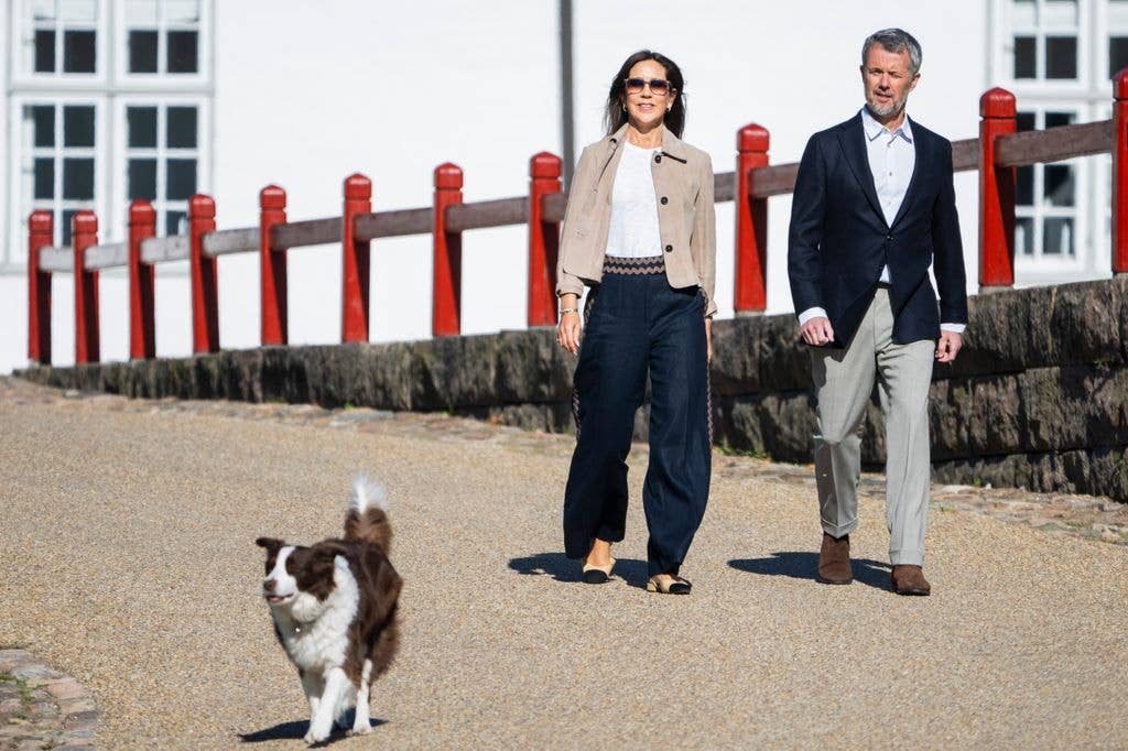 King Frederik and Queen Mary of Denmark and their dog walking outside