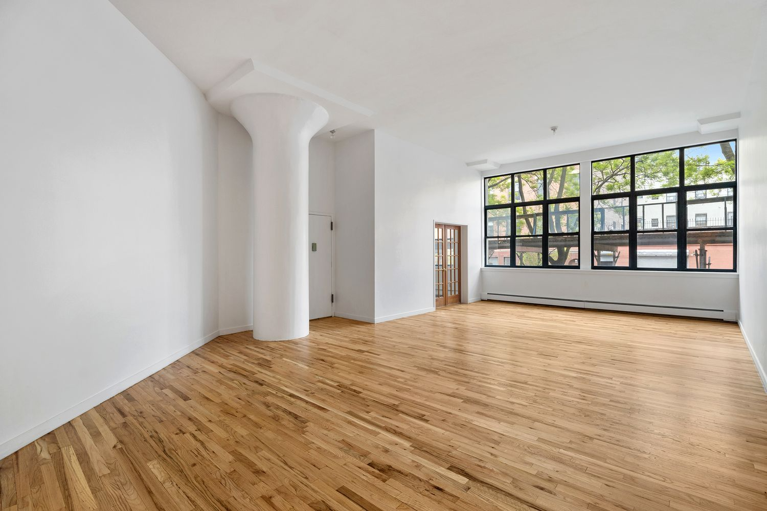 loft living room with column, expanse of windows with sidewalk shed view