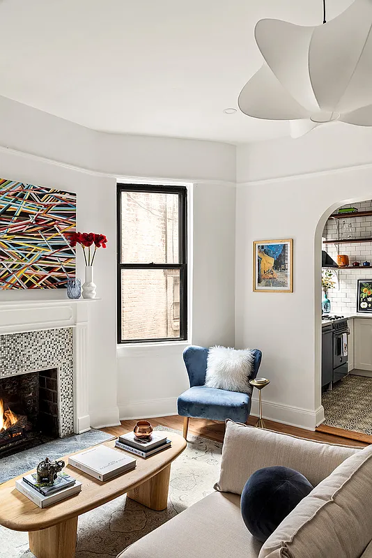 living room with mosaic tile surround on fireplace, white walls