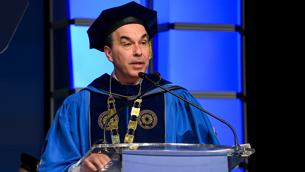 New York Tech President speaking at a podium