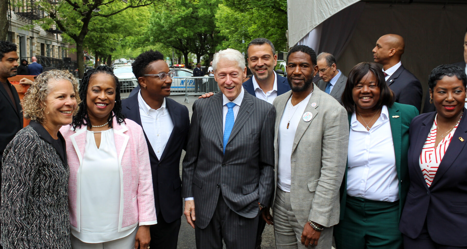group of people posing for a photo with former President Bill Clinton in center