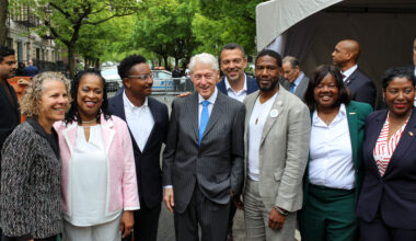 group of people posing for a photo with former President Bill Clinton in center