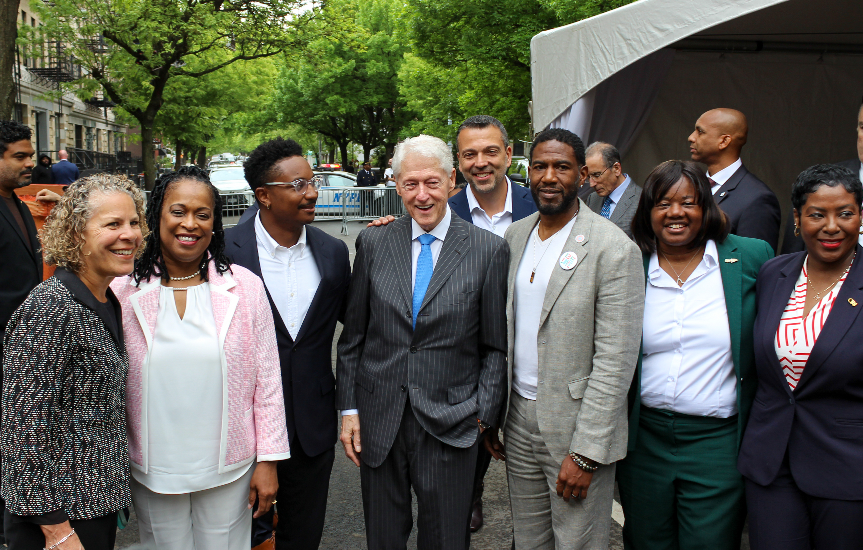 group of people posing for a photo with former President Bill Clinton in center