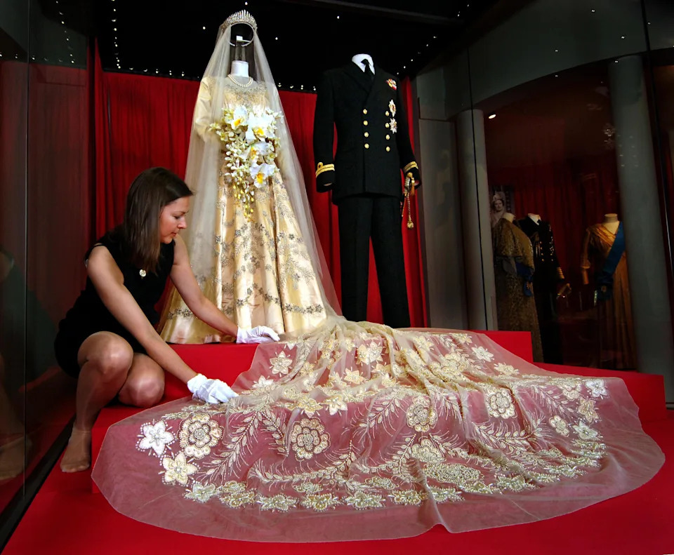The late queen's Norman Hartnell wedding dress and 13 foot train on display