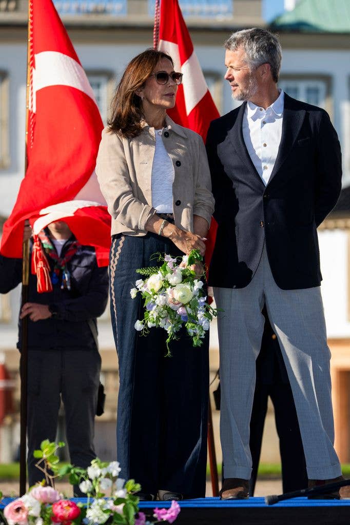 queen mary in trousers standing beside king frederik