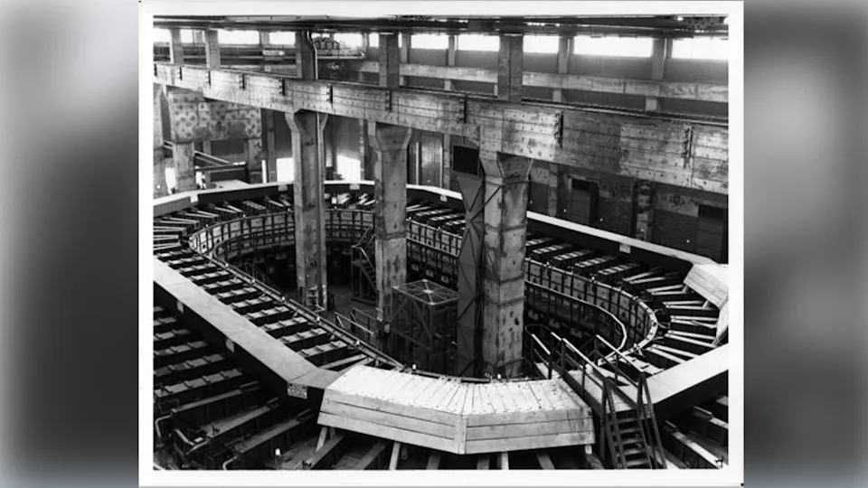 A circular racetrack-like machine in a warehouse.