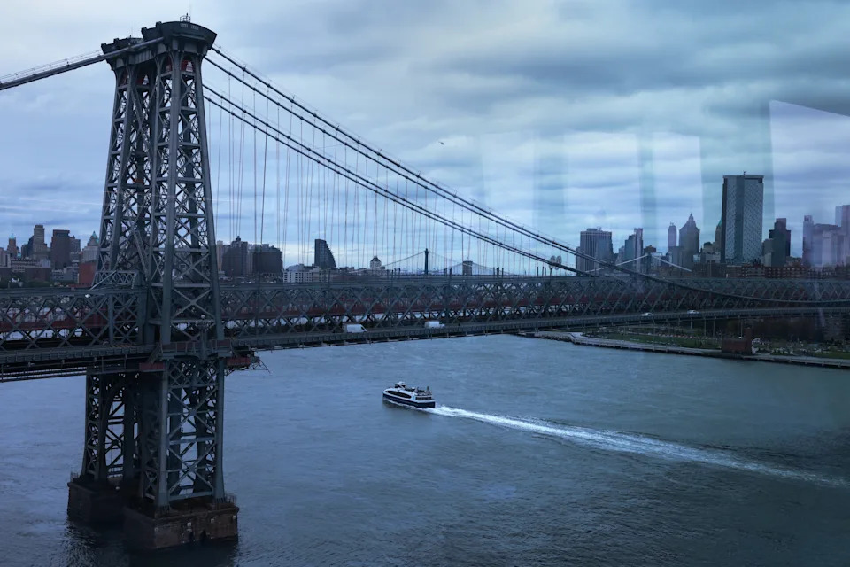 A ferry passes beneath the Williamsburg Bridge in New York City. REUTERS/Shannon Stapleton