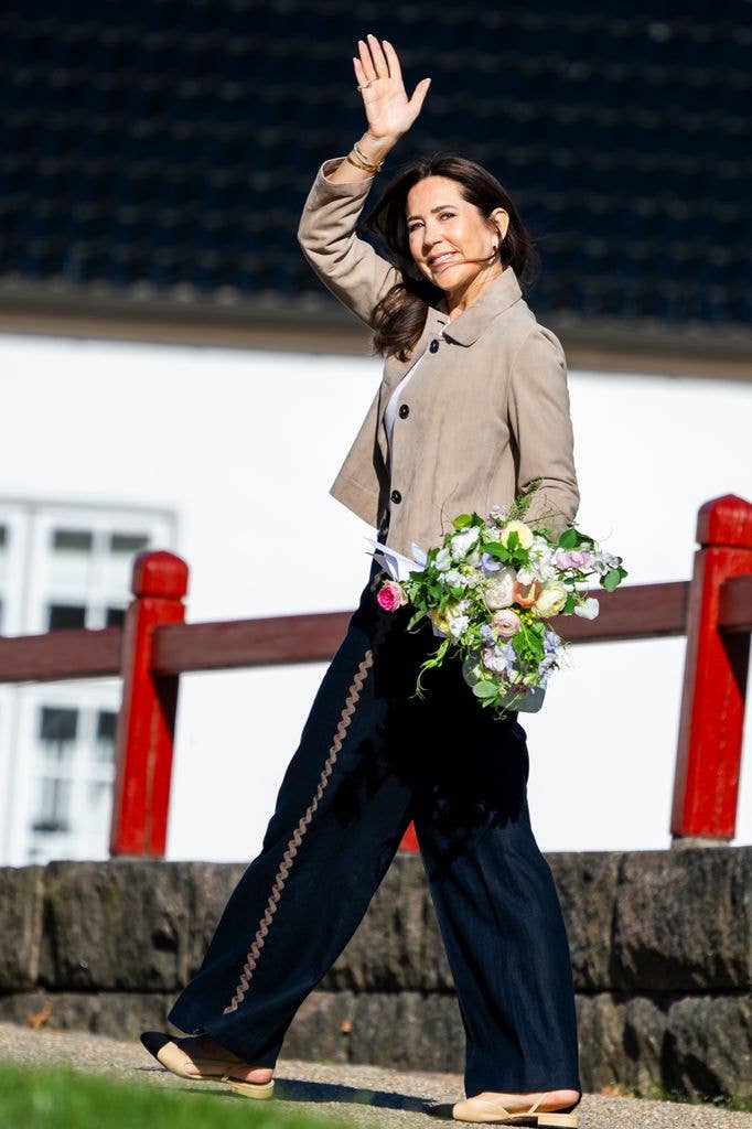 Queen Mary waving holding flowers 