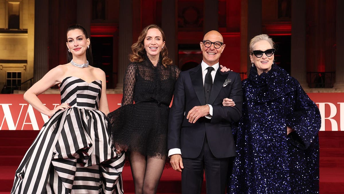 Anne Hathaway, Emily Blunt, Stanley Tucci and Meryl Streep standing together at a gala reception.