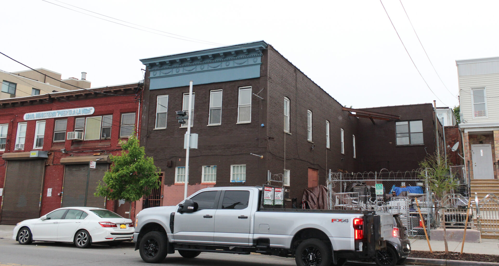 a two story building with a blue cornice
